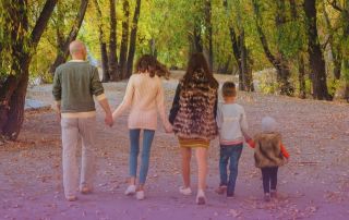 This Image shows a family of 5 walking through the woods